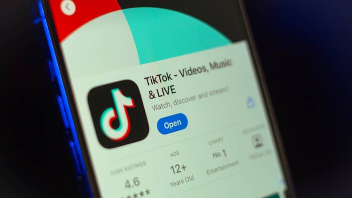 Smartphone screen displaying TikTok app with &quot;Open&quot; button, icon, and app details like rating and age category