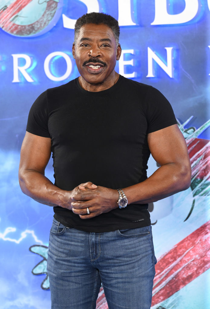 Ernie in a black T-shirt posing with arms crossed in front of a &quot;Frozen 2&quot; movie poster