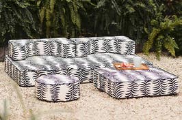 Patterned outdoor sectional with ottoman and a tray with snacks on top