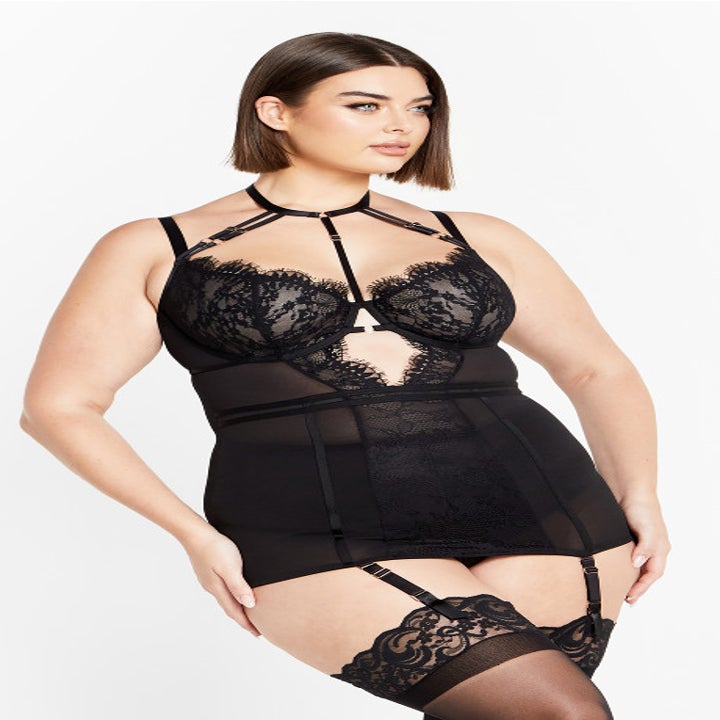 A model showcasing a black lace lingerie set with matching garters