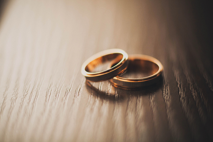 Two wedding bands on a wooden surface, symbolizing marriage and commitment