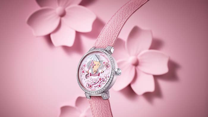Elegant wristwatch with floral theme and crystal embellishments on a pink strap, showcased against a flower backdrop