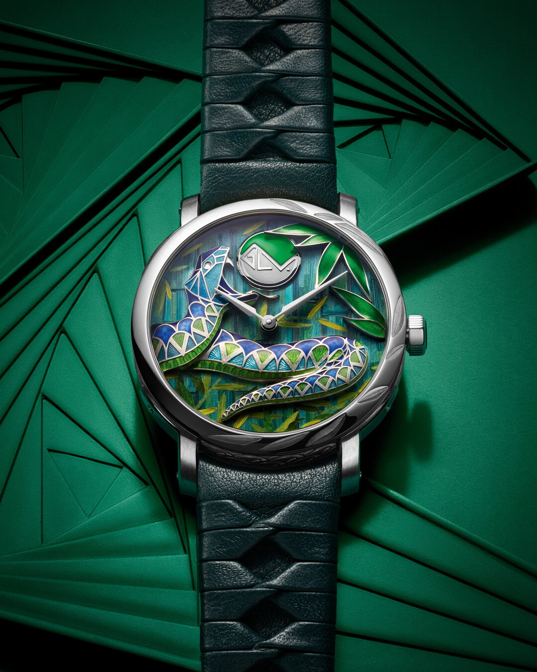 Luxury watch with intricate leaf design on the face and black leather strap, placed on a patterned background