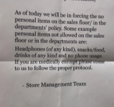 Notice on wall about store policy prohibiting personal items, food, drinks, and headphone use on the sales floor