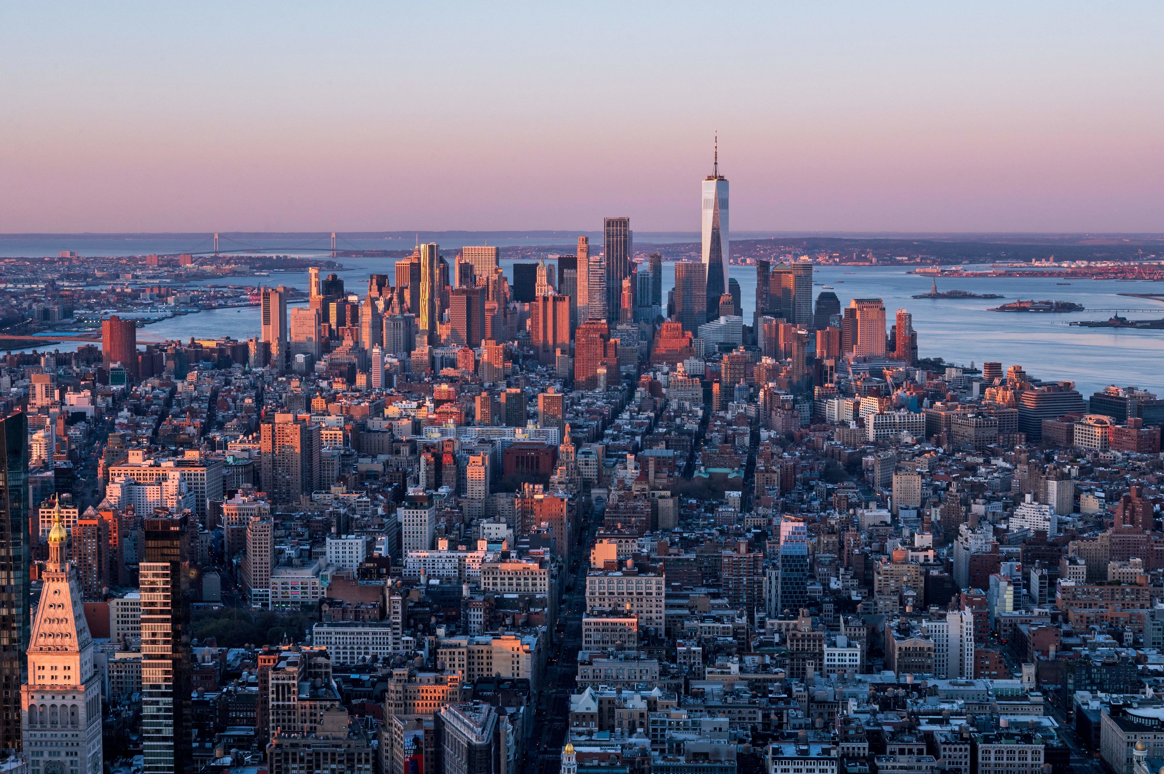 Aerial view of a city skyline at sunset with prominent skyscrapers