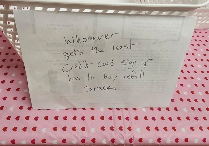 Handwritten note stating, &quot;Whomever gets the least Credit Card sign-ups has to buy retail snacks.&quot;