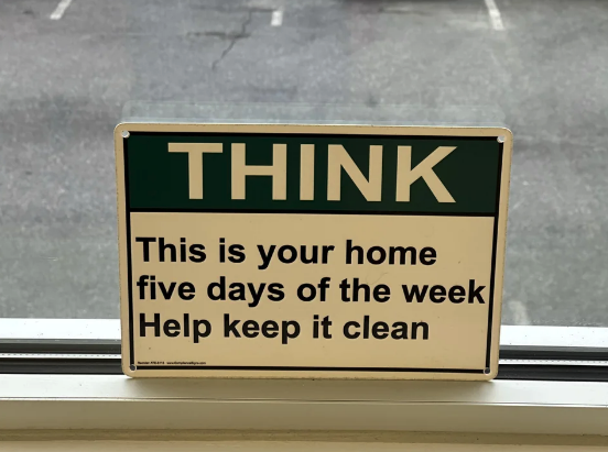 Sign reading: &quot;THINK This is your home five days of the week Help keep it clean&quot; placed on a window sill