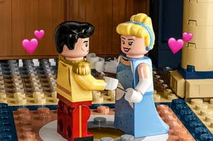 Lego figures of Disney's Cinderella and Prince Charming dancing with hearts above