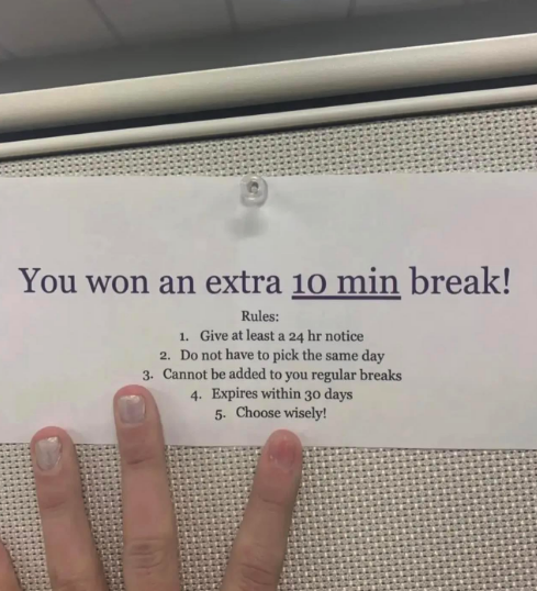 Sign announcing a 10-min break reward with rules; person&#x27;s hand with victory sign
