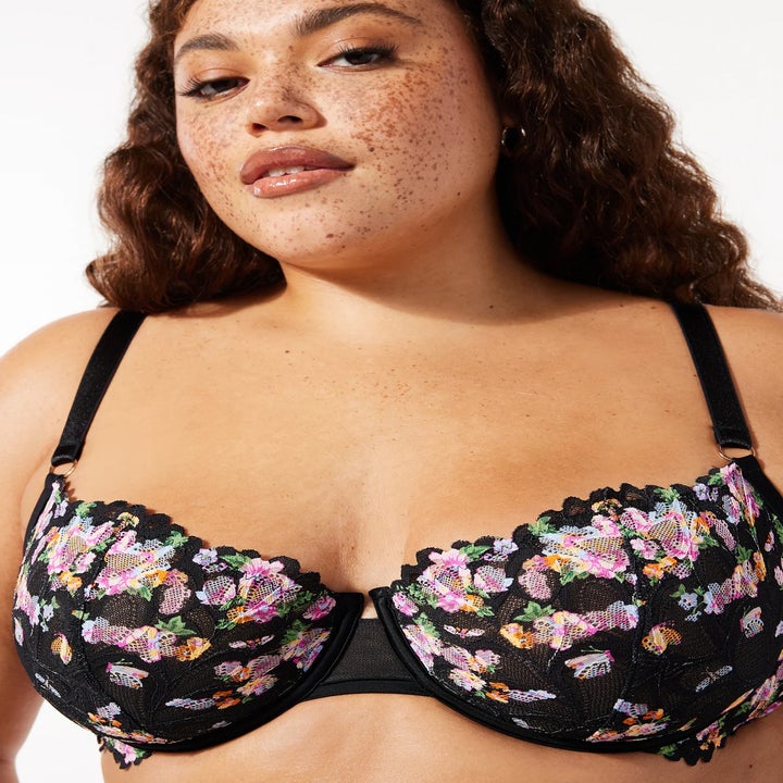 Model wears a black floral-patterned bra
