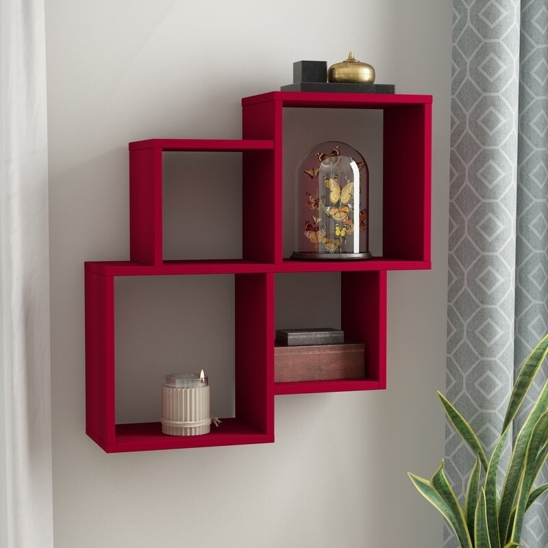 Wall-mounted red shelves with decorative items