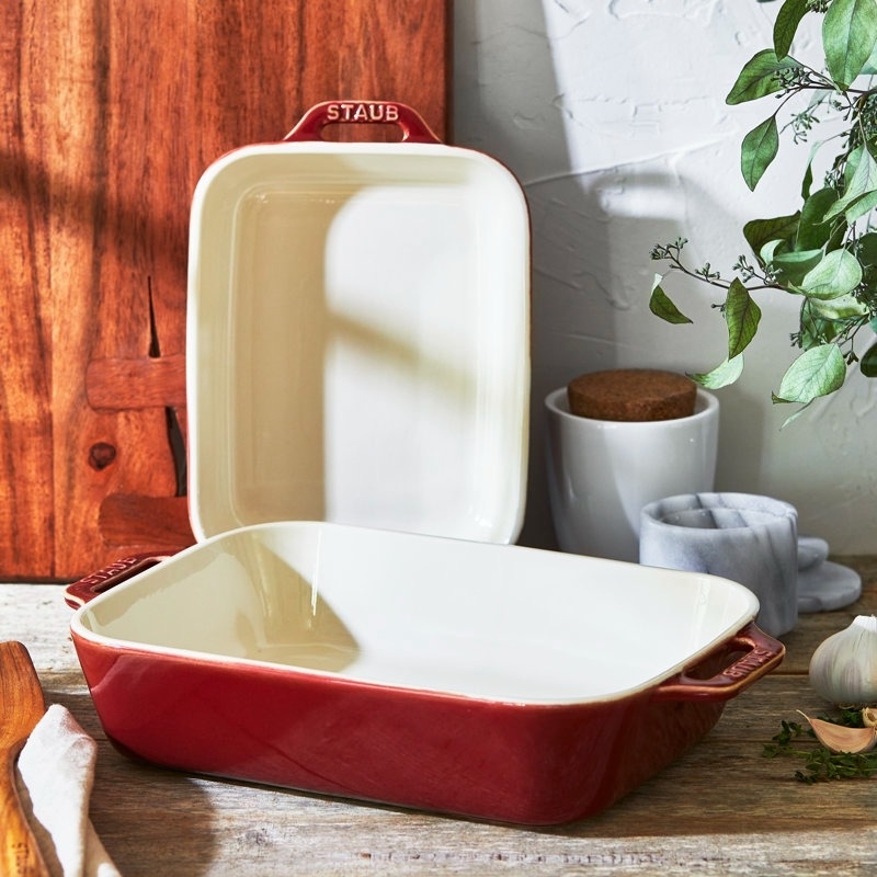 Staub ceramic baking dishes, one stacked on its side, in a cozy kitchen setting
