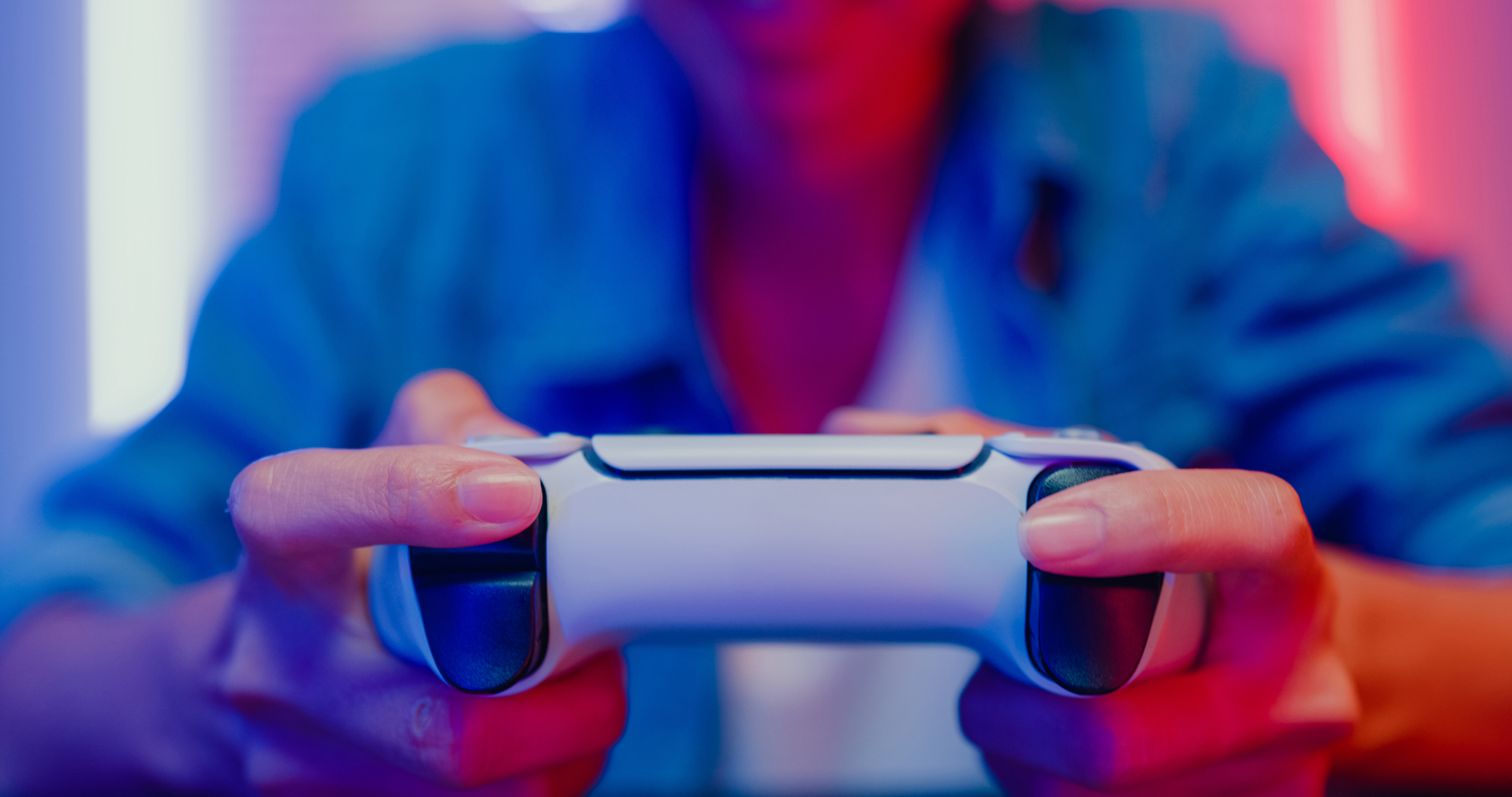 Person holding a game controller, focused on gaming as part of an article on Work &amp;amp; Money in the gaming industry