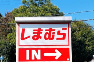 Signboard with Japanese text at the top and 'IN' with an arrow pointing right below it, indicating an entrance