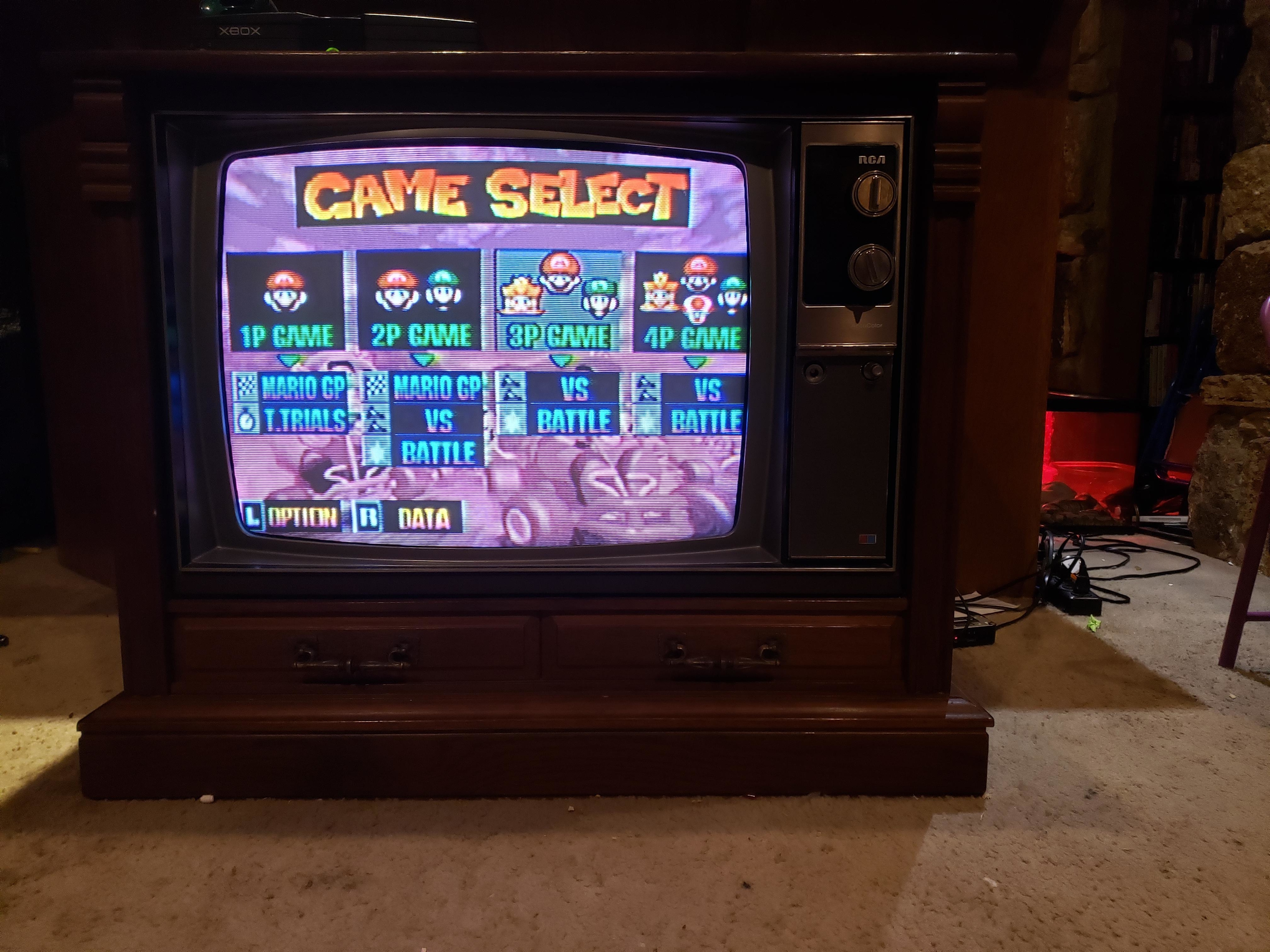 Vintage TV displaying the Mario Kart 64 game menu on a screen with selectable options for gameplay modes