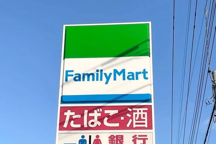 ファミリーマートの看板が青空に映えています。店舗情報とATM利用可能を示すアイコンがあります。