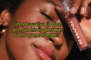 a model poses with this gloss tube while wearing the pink/brown-ish color "cashew"
