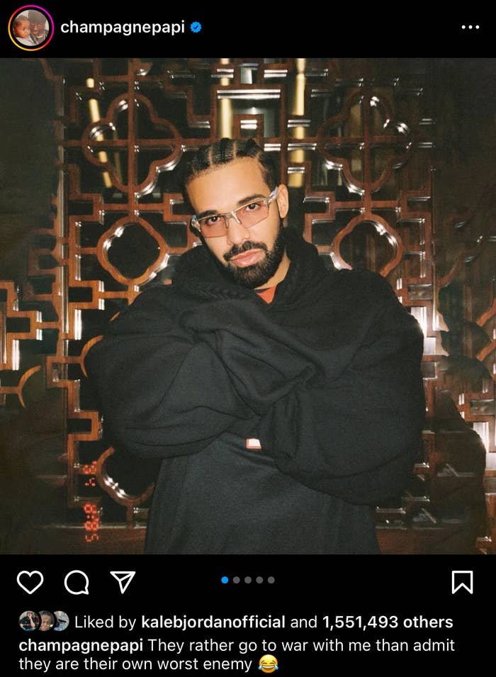 Drake stands in front of an ornate backdrop wearing a black jacket