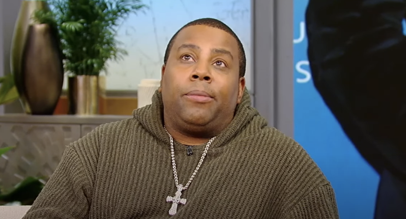 Kenan  in knitted sweater and necklace looks surprised during an interview