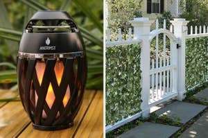 Speaker lantern on a wooden surface next to a white picket fence wrapped in green ivy, suggesting outdoor decor