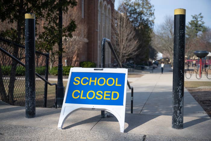 Sign reading &quot;SCHOOL CLOSED&quot; in front of a building, indicating a temporary closure