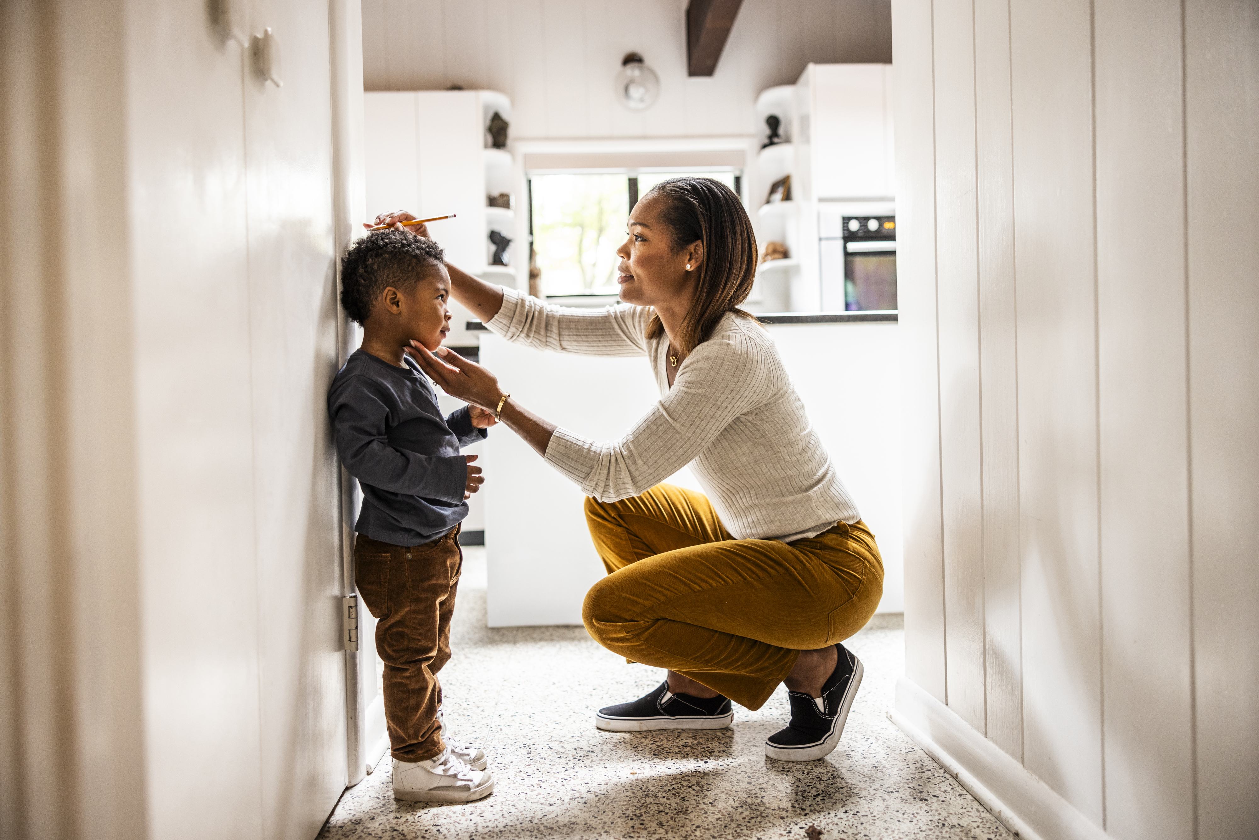 Adult fixing a child's jacket indoors