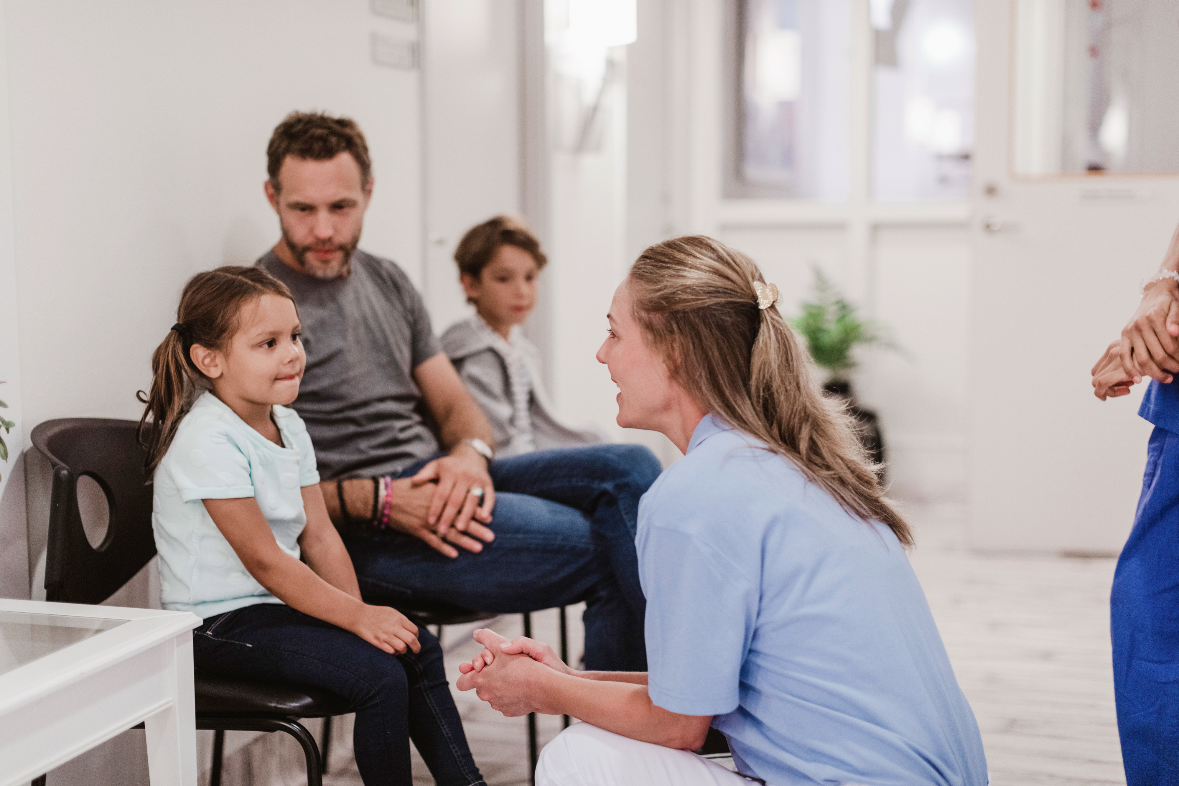 Family with two kids in a medical office, speaking with a healthcare worker