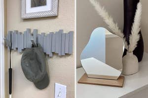 Wall-mounted gray coat rack with a cap hanging; mirror with a unique shape on a wooden stand