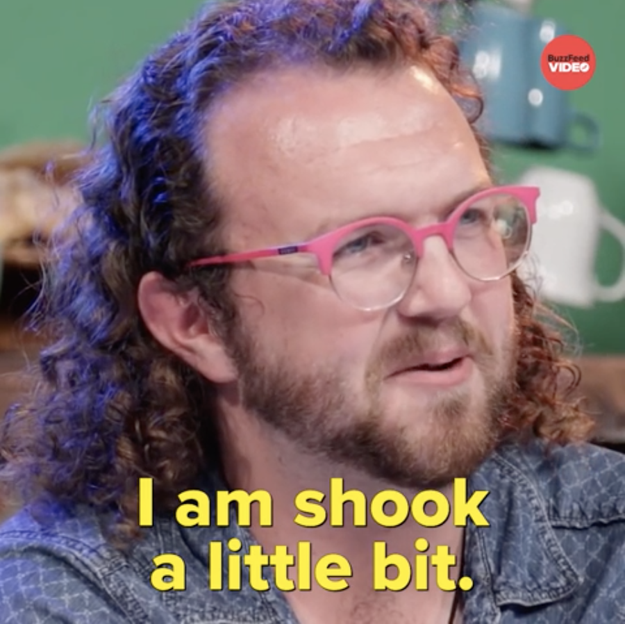 Man with curly hair and pink glasses appears surprised, with caption &quot;I am shook a little bit.&quot;