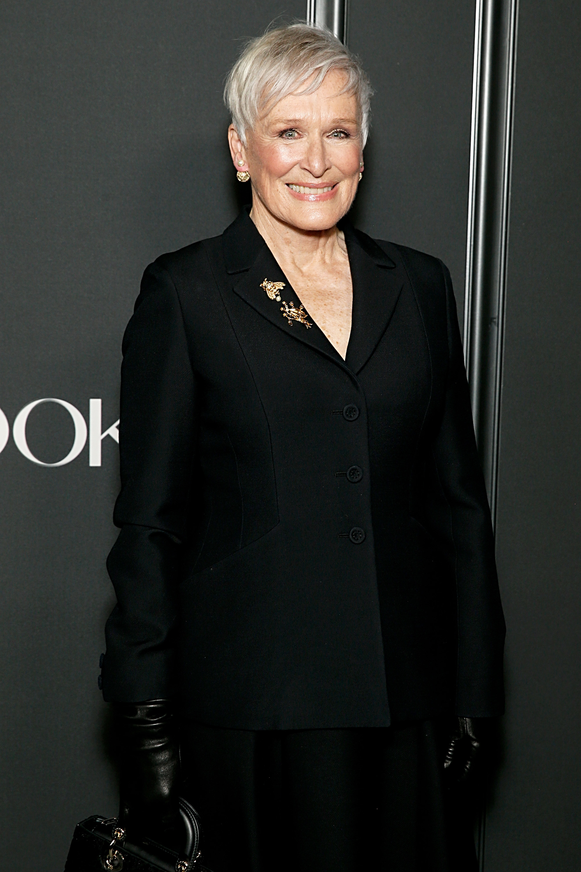 Glenn Close wearing a tailored black blazer, accessorized with a brooch, at an event