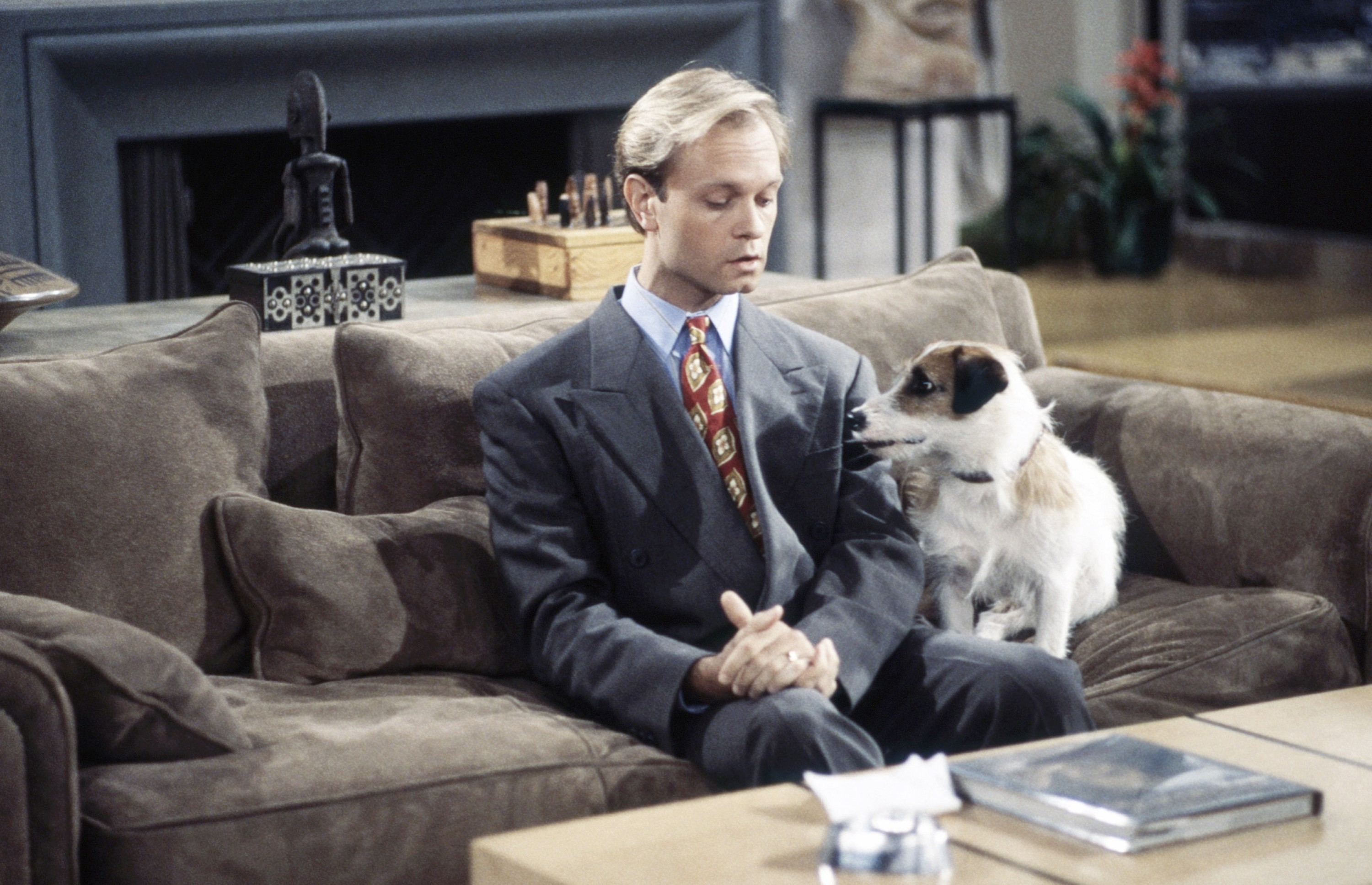 David as Niles Crane sitting on a couch, looking at Eddie the dog