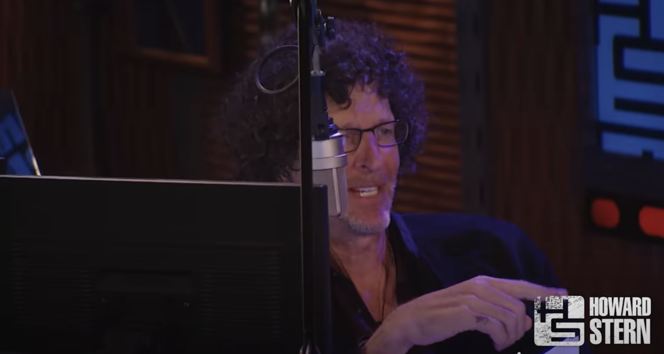Howard speaking into a microphone in a radio studio