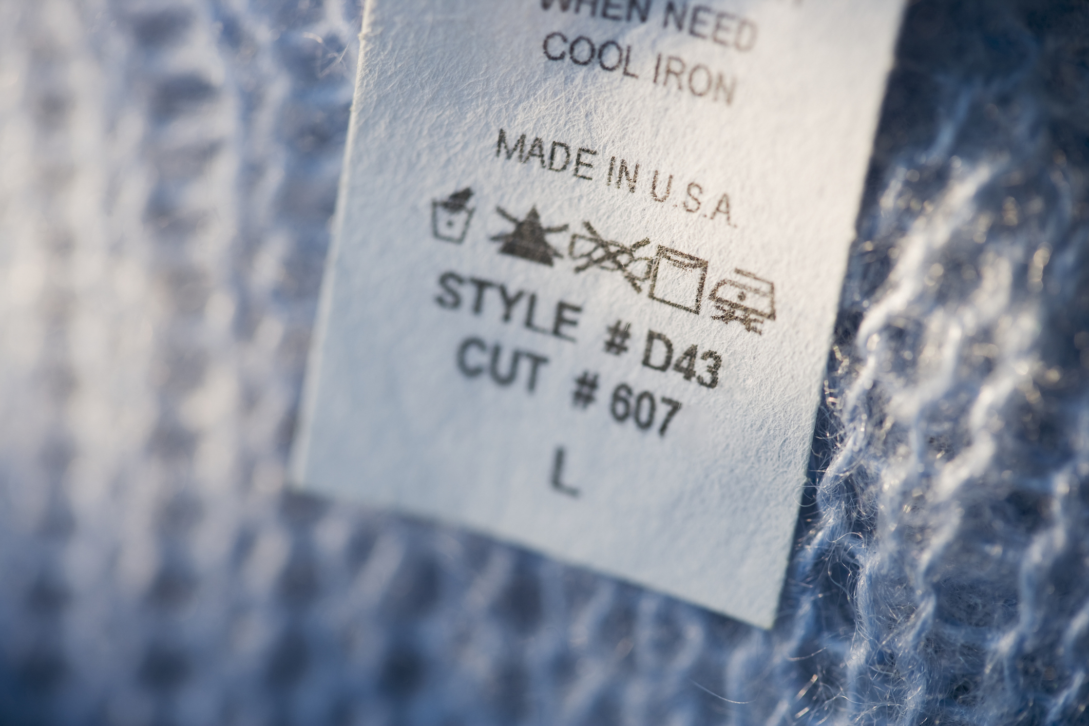 Care label on clothing with washing instructions and size L
