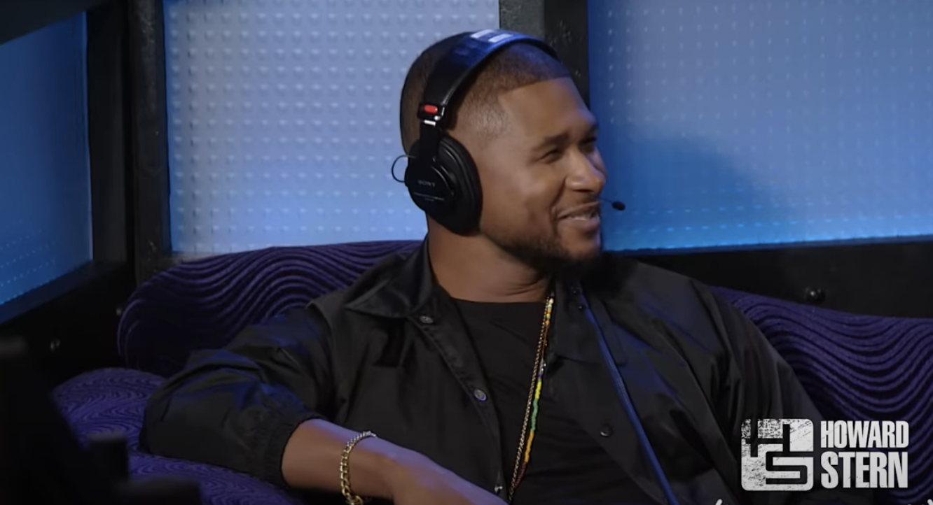 Usher in a studio with headphones smiling, on &quot;The Howard Stern Show&quot;
