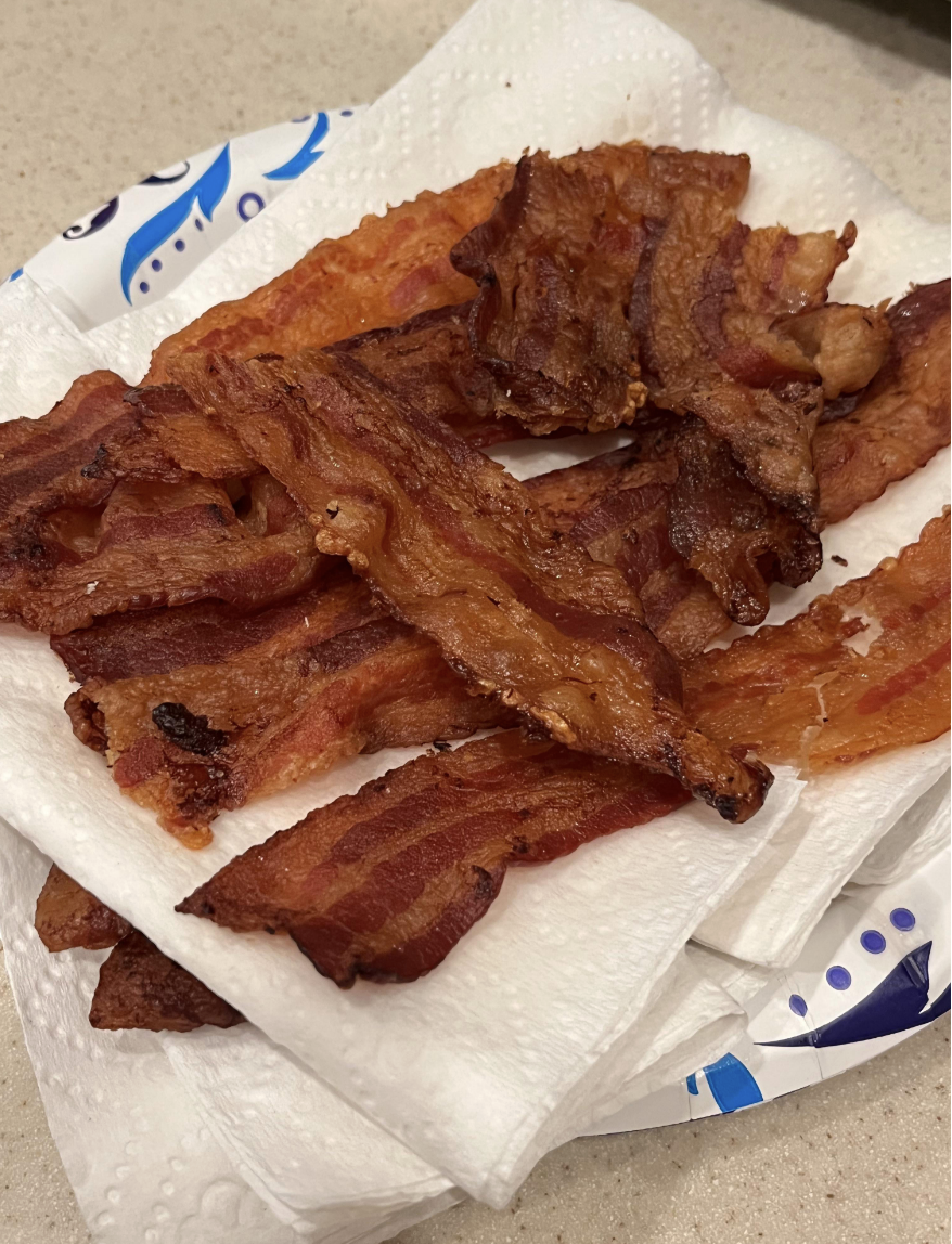 Crispy bacon strips on a paper towel-lined plate