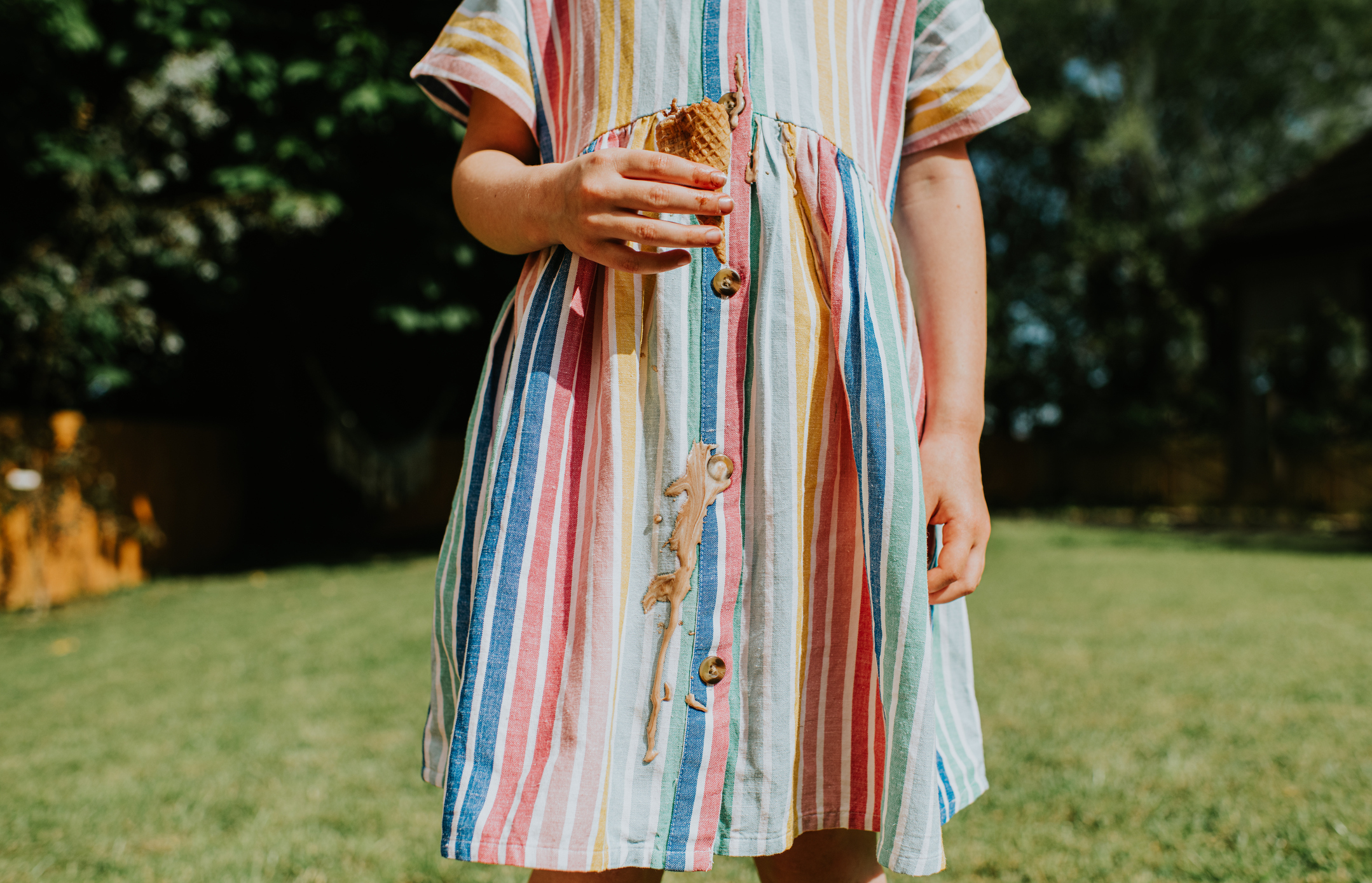 Person in a striped dress holding an ice cream cone