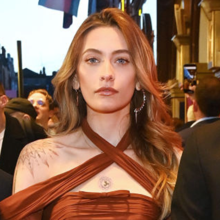 Person in an elegant strap dress at an event, makeup done, with hair styled straight