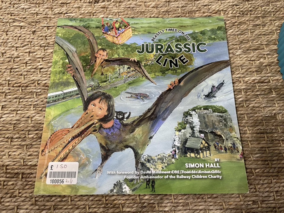 Cover of &quot;Jurassic Line&quot; book by Simon Hall featuring illustrations of dinosaurs and trains with a foreword by David Maidment