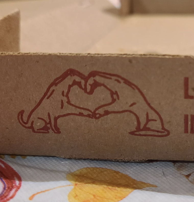 Two hands forming a heart shape drawn on cardboard