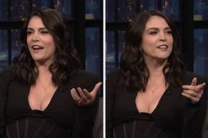 Woman with dark hair in a black dress gesturing while talking on a talk show