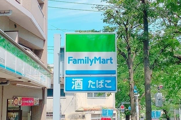 ファミリーマートの看板が建物の上にあり、背景に木が見えます。