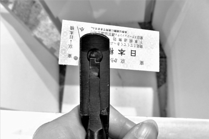 手に持たれた鍵とラベル、ラベルには日本語の文字が書かれている。
