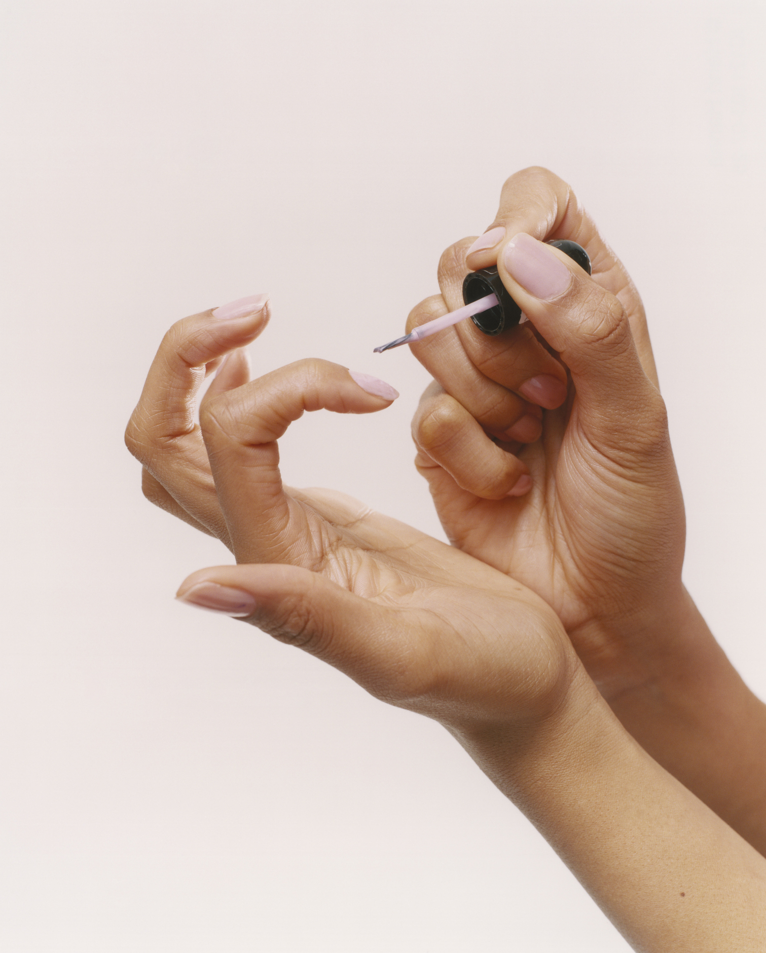 A person applying nail polish to fingernails, possibly in preparation for a wedding ceremony