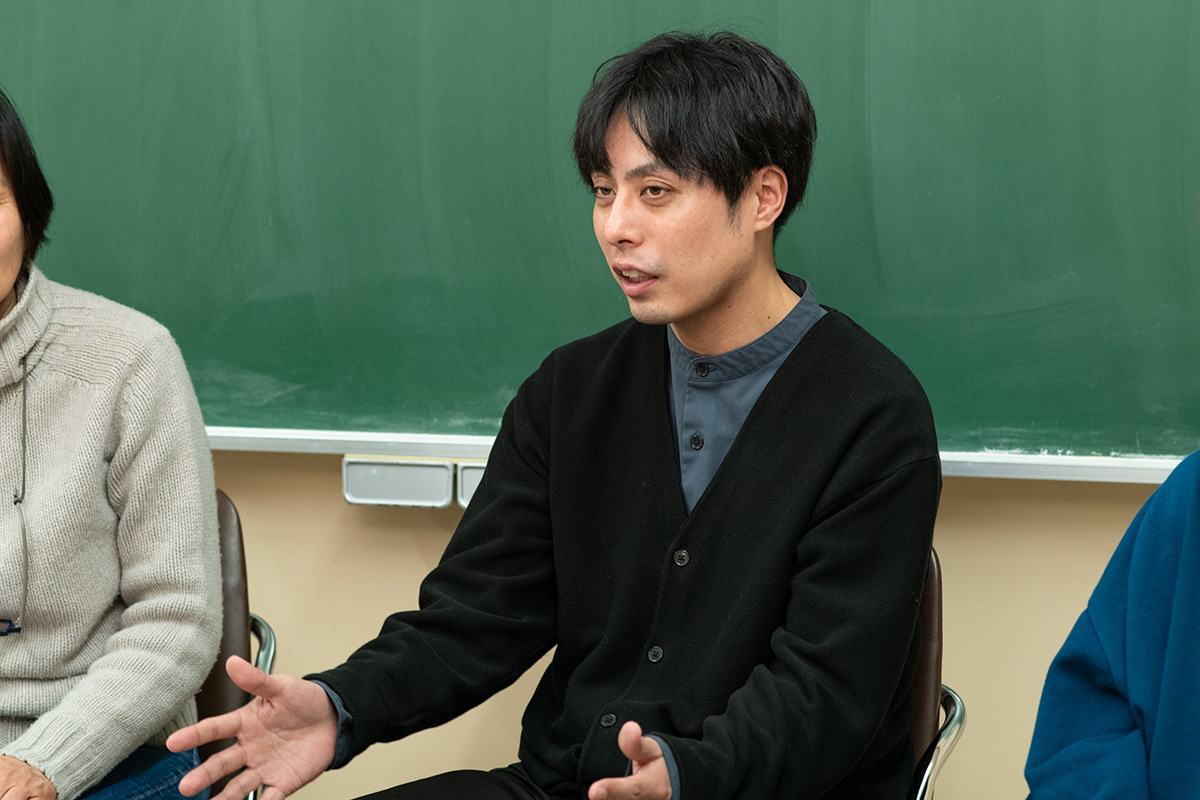 男性が会議で話しているシーンです。