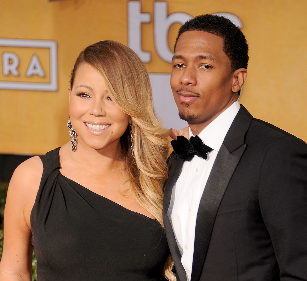 Mariah Carey and Nick Cannon pose together, both dressed in formal attire