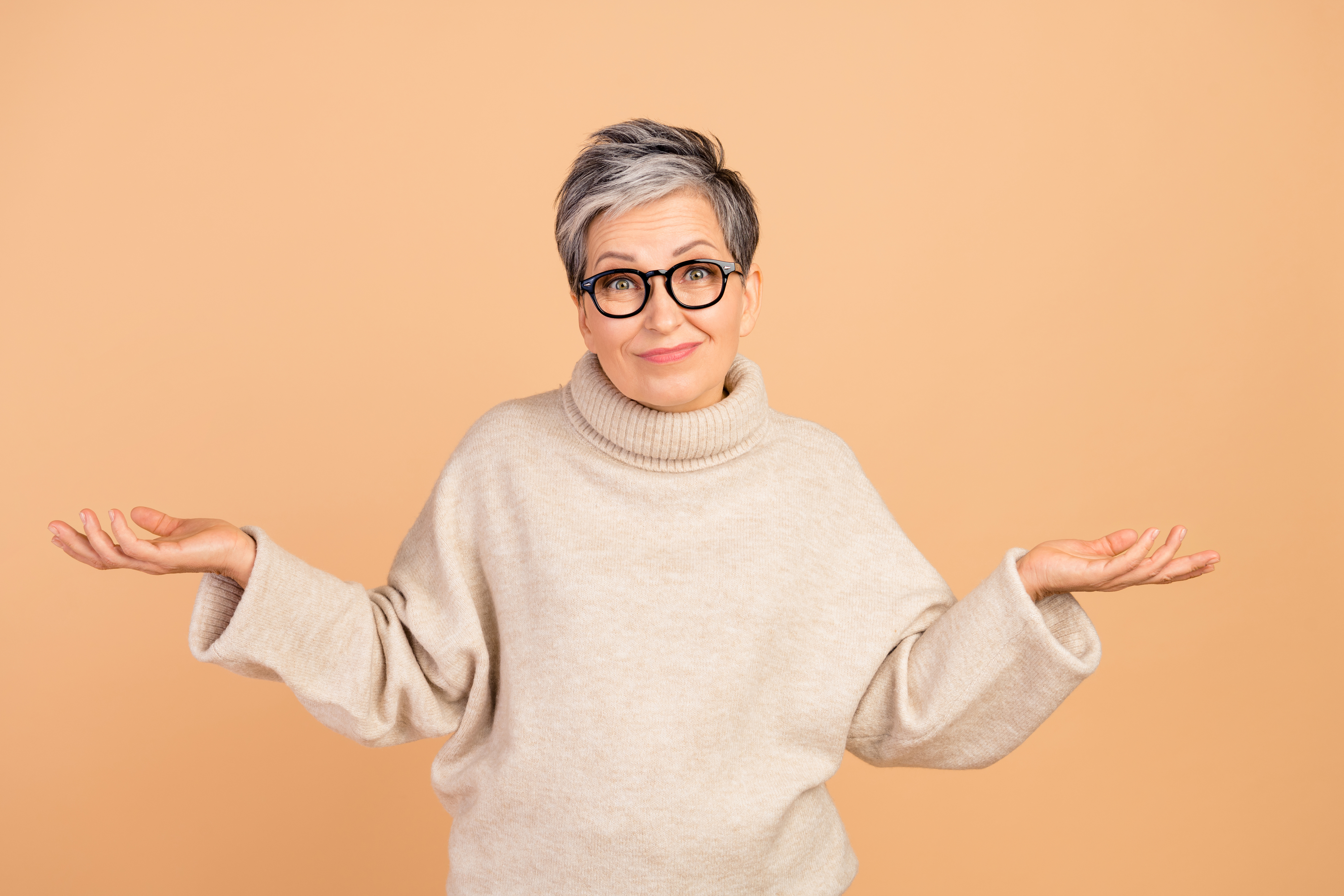 Woman with glasses nad arms outspread expressing uncertainty