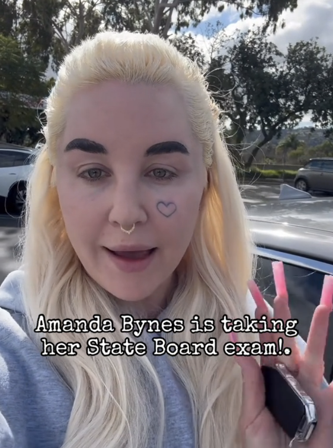 Amanda Bynes with a heart tattoo on her face, talking to the camera about taking her State Board exam