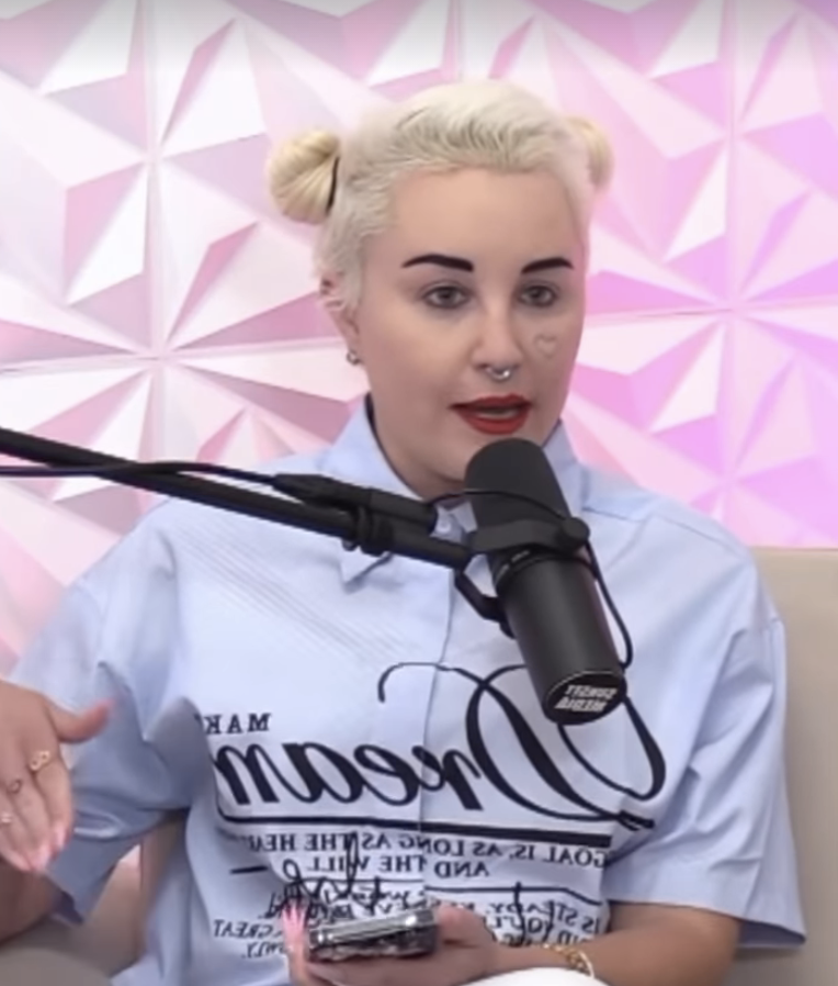 Amanda with double-buns hairstyle, wearing a graphic T-shirt, speaking and gesturing with her hand