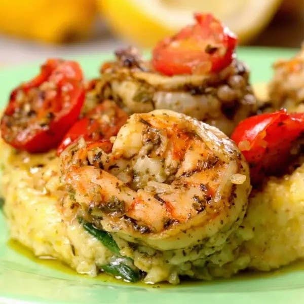 Shrimp on a bed of grits with herbs and roasted tomatoes