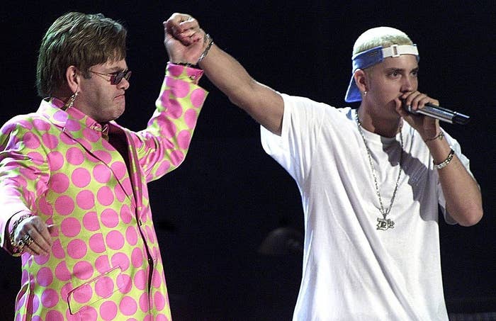 Elton John in a polka-dotted outfit and Eminem in a white shirt and jeans perform together onstage